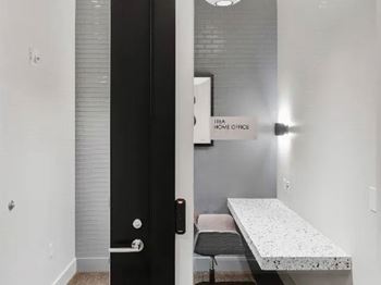 A black door with a handle and a sign that says "The Home Office" on the wall.